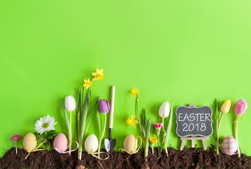 Easter flower bed garden background with row of painted eggs amongst flowers