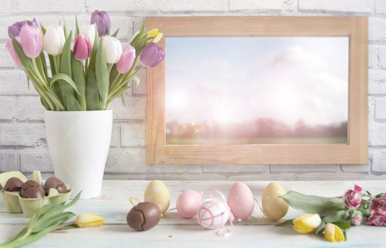 Easter eggs and spring flowers in a vase next to a window 