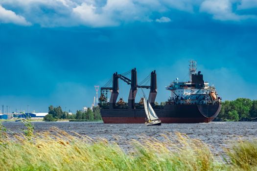 Merchandise import. Large blue cargo ship moving to Riga port