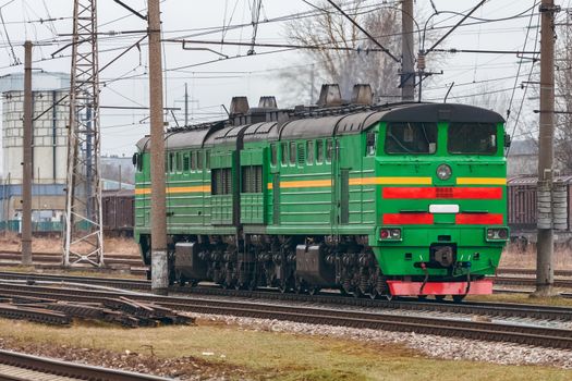 Green diesel cargo locomotive. Freight train in action