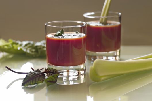 still life with tomato juice in glass glasses with greens