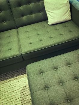 Comfortable green sofa with foot stool. Modern design with retro feel.