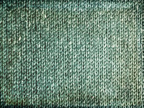 Grungy faded green knitted background. Handcrafted rustic canvas.