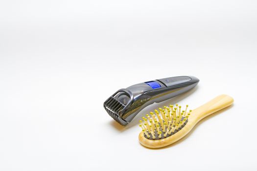 Hair brush comb with scraping hair and clipper on a white background.