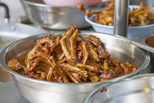 Fried duck feet in a silver container.