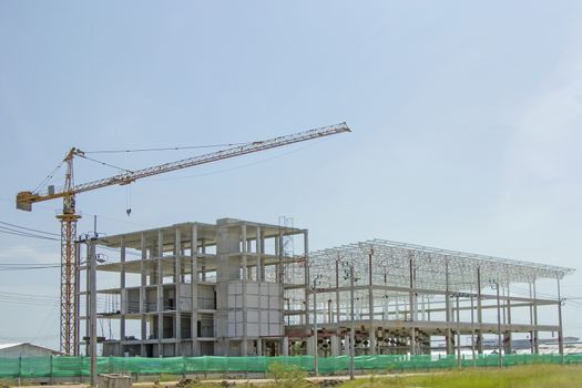 Crane lift with factory under construction.