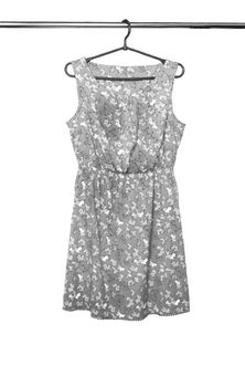Summer dress with a butterfly pattern hanging on a hanger, isolated.