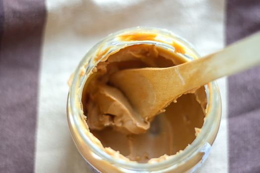 an open jar of peanut butter with spoon