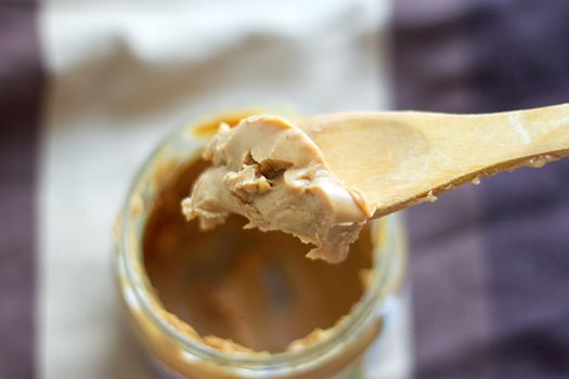 an open jar of peanut butter with spoon