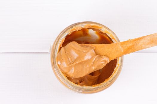 an open jar of peanut butter with spoon