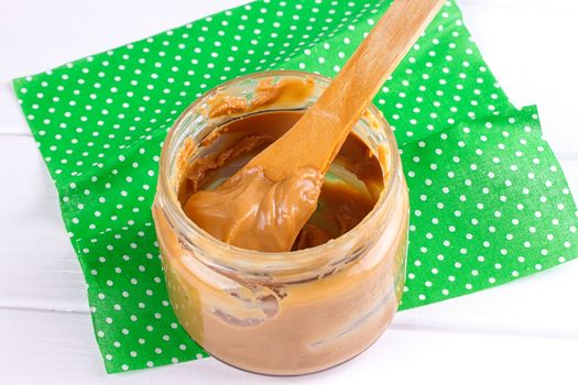 an open jar of peanut butter with spoon