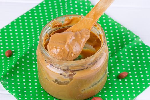 an open jar of peanut butter with spoon