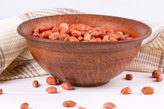 Peanuts in a brown plate. on white background