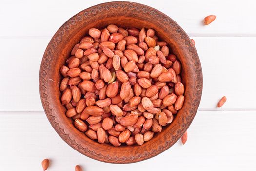 Peanuts in a brown plate. on white background