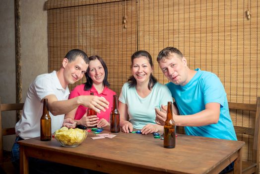 smiling friends while playing poker at the table