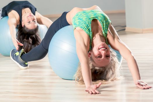 a happy woman in a group doing pilates on gymnastics balls