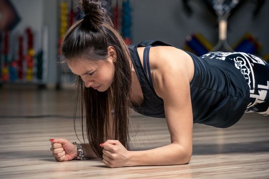 sporty woman performing an exercise strap on the floor in the gym