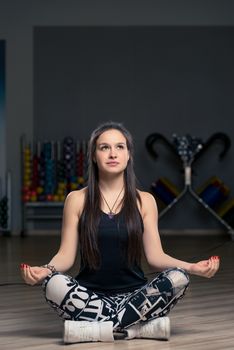 beautiful brunette doing yoga at the gym, lotus pose