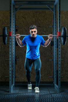 strong athlete in training in the gym with a barbell