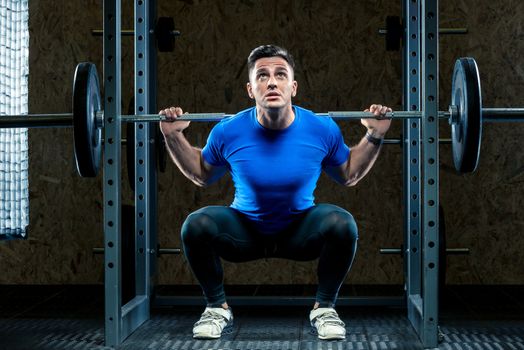 horizontal portrait of a bodybuilder with a barbell making an effort in the gym, an athlete in training