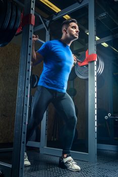 portrait of a bodybuilder with a barbell in the gym during training, bottom view