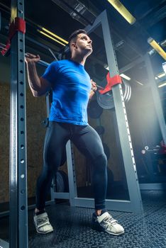 portrait of an athlete in a gym with a heavy barbell