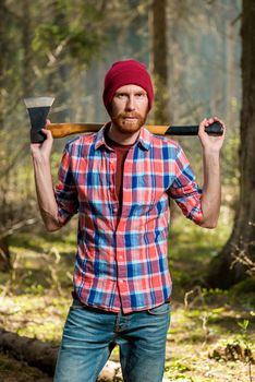 severe bearded forester with an ax vertical portrait in the forest