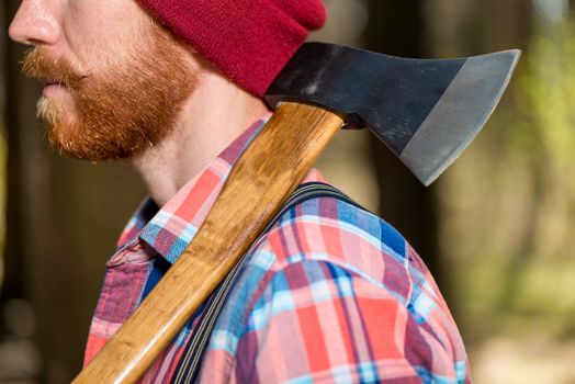 ax on the shoulder of a bearded forester close-up