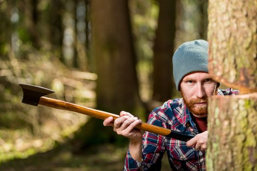 lumberjack with an ax and tree trunk, focus on the face