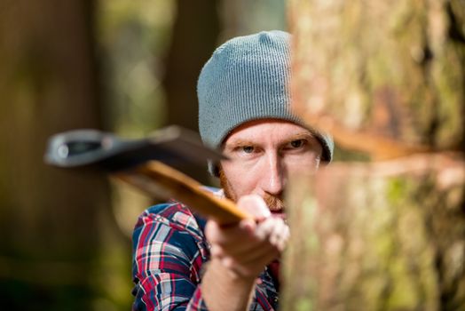 hipster woodcutter chopping wood, focus on eyes