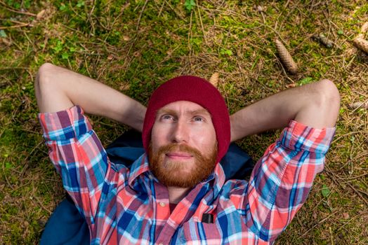 dreamy hipster on the ground in the woods resting and looking at the sky