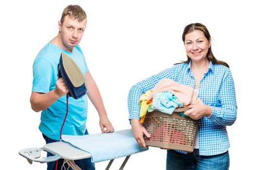 woman with laundry basket and man with iron on white background while ironing clothes