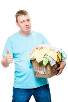 happy man with a basket of clean laundry for ironing on a white background isolated