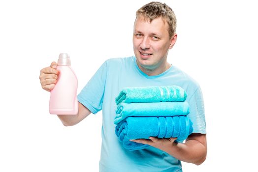 portrait of happy husband with clean towels and gel for washing clothes on white background