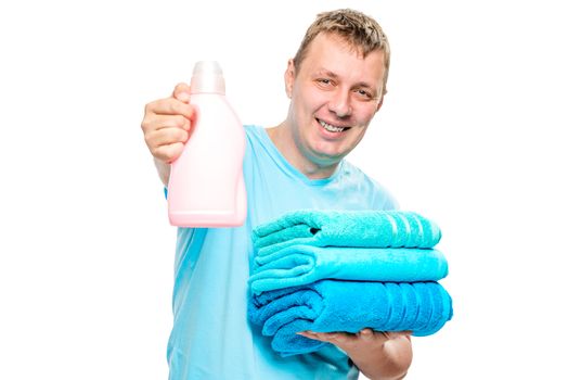 happy householder with clean towels and a gel for washing clothes on a white background