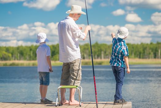 boys with father on fishing in a beautiful place on the lake