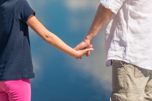 father and daughter hold hands, close-up hands