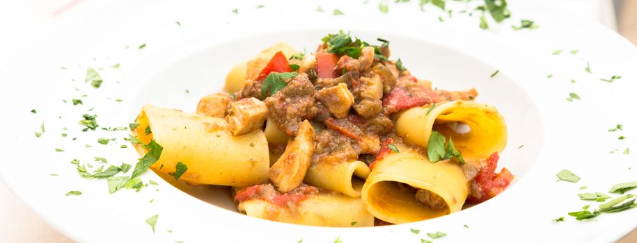 Otranto town, Puglia Region, South of Italy. Traditional Paccheri pasta with Swordfish, served with tomato, parsley, olive oil. Daylight, real restaurant in Otranto.