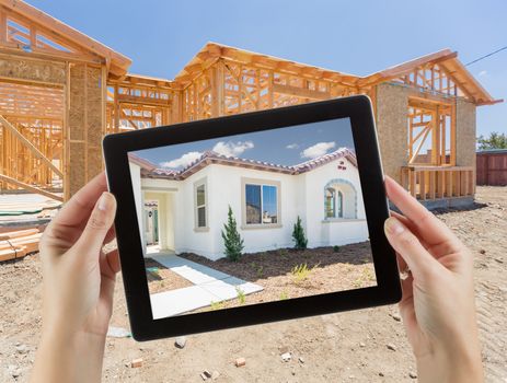 Female Hands Holding Computer Tablet with Finished House on Screen, Construction Framing Behind.