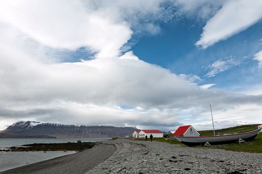 Houses and boat in front of the beach in Vigur island, Iceland