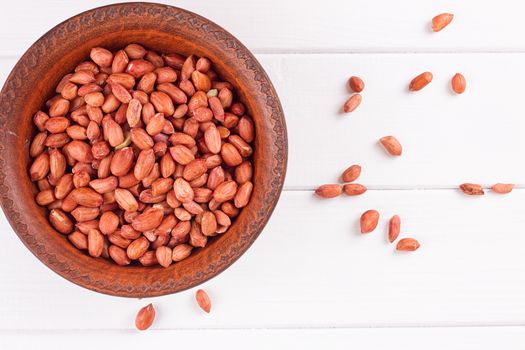 Peanuts in a brown plate. on white background