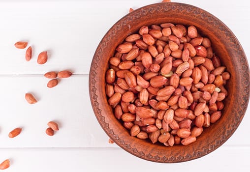 Peanuts in a brown plate. on white background