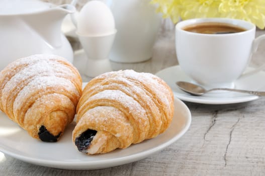 Croissants with chocolate filling cup and fresh morning coffee. Foreground close-up