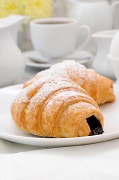 Croissants with chocolate filling cup and fresh morning coffee. Foreground close-up