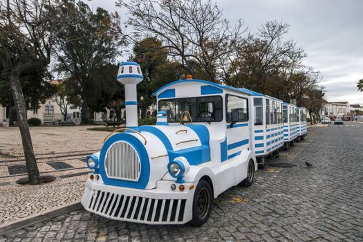 Close view of a long Tourist train in faro city parked on garden Manuel Bivar near the docks.