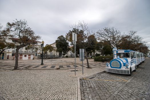 Close view of a long Tourist train in faro city parked on garden Manuel Bivar near the docks.