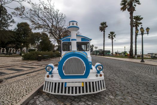Close view of a long Tourist train in faro city parked on garden Manuel Bivar near the docks.