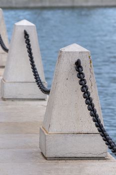 Faro city docks details of pillars and the edge with chains.