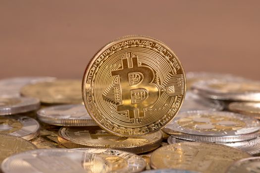 several aligned crypto currency coins on top of wooden table.