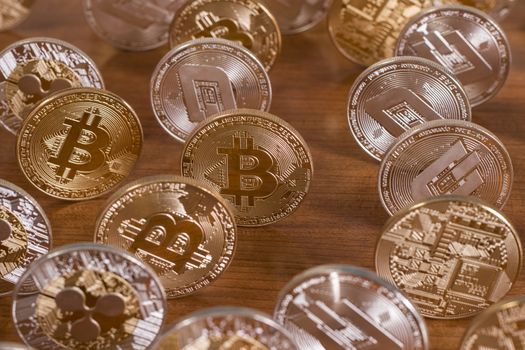 several aligned crypto currency coins on top of wooden table.